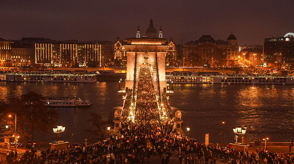 Szilveszteri tömeg az Erzsébet hídnál Budapesten, ünnepi fények és nyüzsgés a városban este.