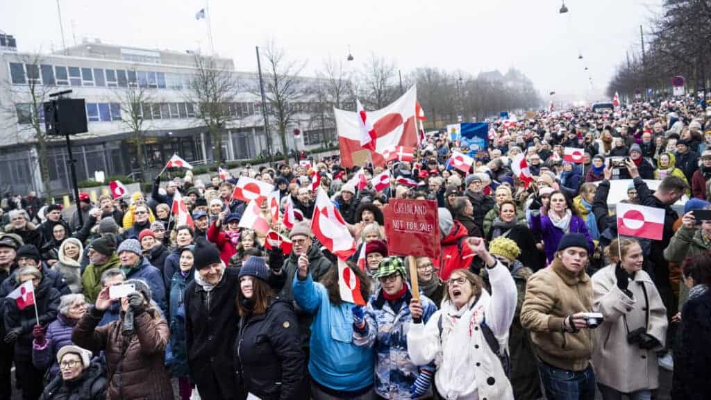 Békés tüntetésen sokan gyűlnek össze, zászlók és táblák a környezetvédelmi kérdésekért.